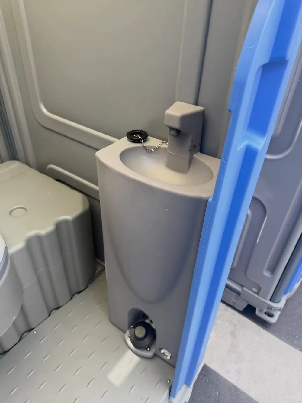 Gray deluxe unit interior with foot-pump hand sink