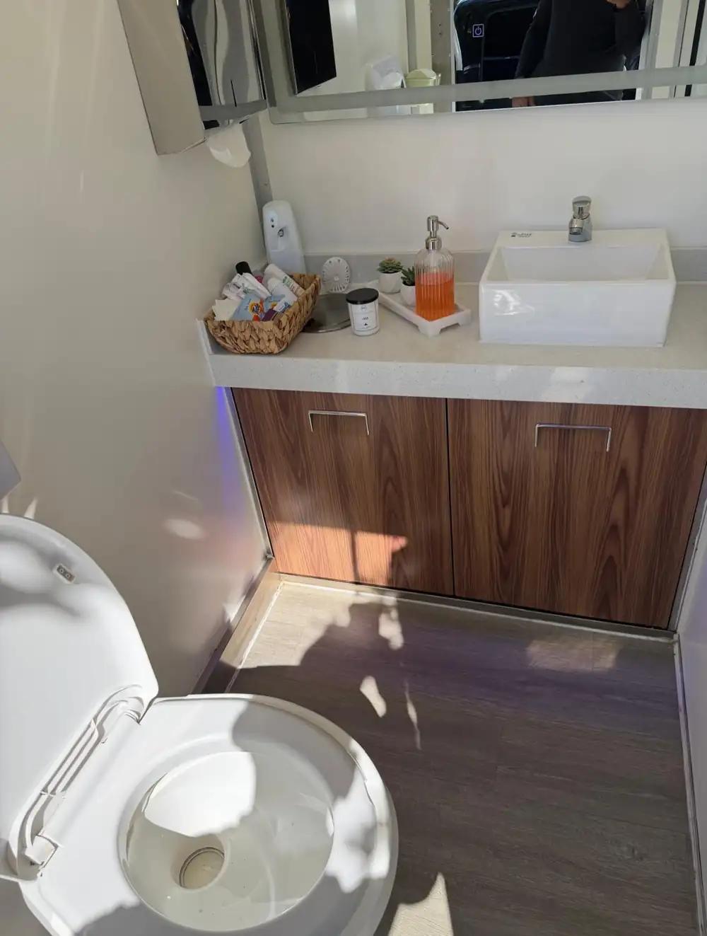 Restroom trailer vanity with vessel sink and wood cabinet